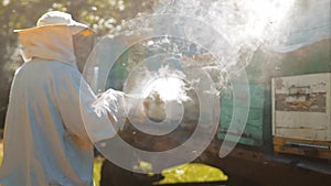 Bee-maker beekeeper man working of a smoke pipe beeper smoker device for repelling evil bees lifestyle. slow motion