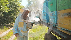 Bee-maker beekeeper man working of a smoke pipe beeper wooden hives smoker device for repelling evil bees. slow motion