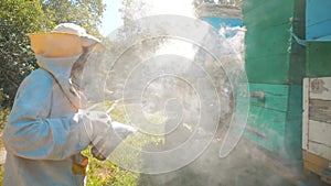 Bee-maker lifestyle beekeeper man working of a smoke pipe beeper smoker device for repelling evil bees. slow motion