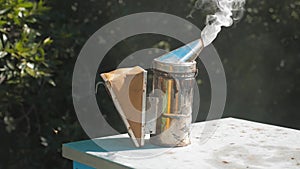 Bee-maker of a smoke pipe beeper smoker device for repelling evil bees. slow motion video apiary. lifestyle beekeeping