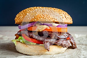 Beef burger with tomato, salad, onion, pepers and cheese