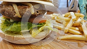 Beef Burger with Vegetables and French Fries on Wooden Plate