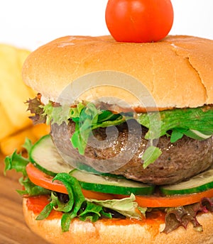 Beef burger on the wooden plate with fried potato