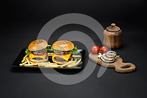 Beef burgers with french fries in a black plate