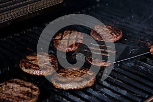 Beef burgers grilling close up BBQ burgers prepared on barbecue fire flame grill with beef meat