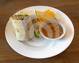 Beef burrito with corn chip tortilla and salsa