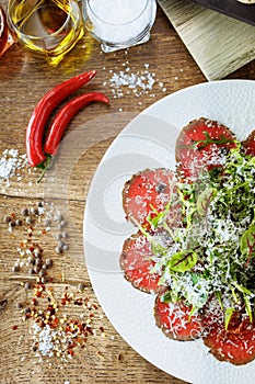 Beef carpaccio. Borettane onion, sun-dried tomato, truffle dressing, arugula salad, parmesan cheese. Italian traditional