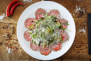 Beef carpaccio. Borettane onion, sun-dried tomato, truffle dressing, arugula salad, parmesan cheese. Italian traditional