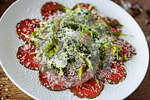 Beef carpaccio. Borettane onion, sun-dried tomato, truffle dressing, arugula salad, parmesan cheese. Italian traditional