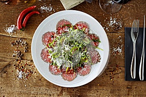 Beef carpaccio. Borettane onion, sun-dried tomato, truffle dressing, arugula salad, parmesan cheese. Italian traditional