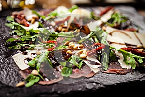 Beef carpaccio served on a board. Delicious healthy Italian traditional antipasti snacks closeup served for lunch with