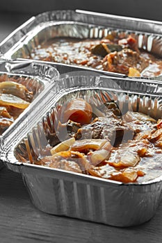 Beef casserole, with herbs and vegetables, in a tomato sauce. In foil trays. Batch cooking concept