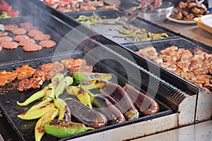 Beef and chicken steaks on the grill with flames.