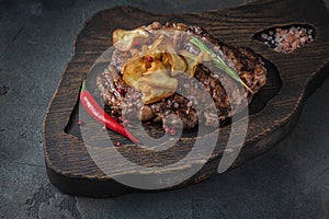 Beef chuck roll steak on wooden board, close view