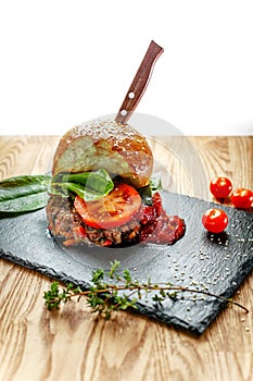 Beef cutlet with tomatoes with roll from hamburger and fresh vegetables without harmful additives for healthy nutrition