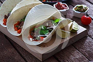 Beef Fajitas with colorful bell peppers in pan and tortilla bread and sauces