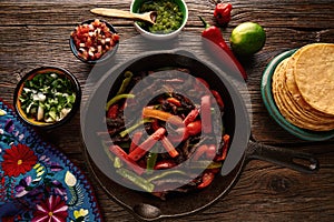 Beef fajitas in a pan with sauces Mexican food