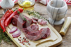 Beef. Fresh raw meat on a cutting Board, olive oil, garlic, hot pepper, thyme and spices
