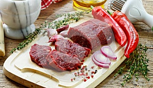 Beef. Fresh raw meat on a cutting Board, olive oil, garlic, hot pepper, thyme and spices