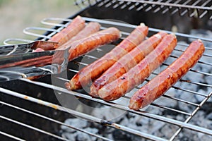 Beef fried sausages on fire on a portable barbecue