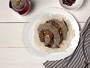 Beef goulash-delicious goulash in a white plate on a wooden white table. Filipino cuisine-Adobo beef.