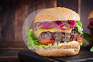 Hamburger. Sandwich with beef burger, tomatoes, cheese, pickled cucumber and lettuce. Cheeseburger