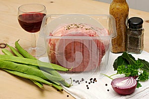 Beef joint in a clear plastic tray, arranged with beans, onion other ingredients