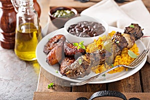 Beef kebab with rice, beans and fried plantains
