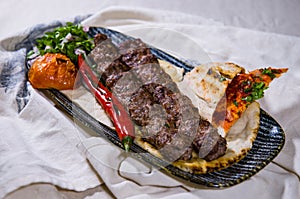 beef, lamb or mutton seekh kabab meat kebab with pita bread, tomato and onion served in dish isolated on food table top view of