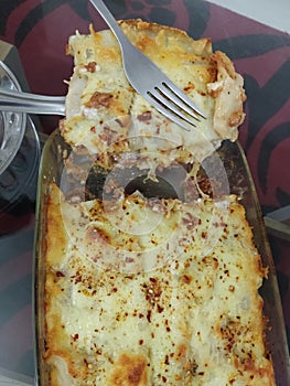 Beef Lasagne home made dish served in glass tray on the black table in lockdown days of covid 19 photo