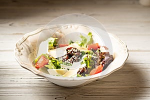 Beef liver and salad leaves, parmesan cheese slices and cherry tomatoes. Healthy food concept.