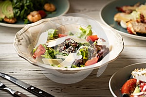 Beef liver and salad leaves, parmesan cheese slices and cherry tomatoes. Healthy food concept.