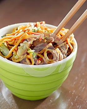 Beef lo mein in a bowl with chopsticks photo