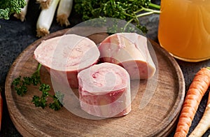 Beef marrow bones and fresh vegetables - ingredients to prepare bone broth or soup