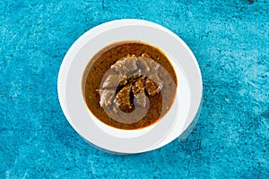 Beef masala curry in a plate isolated on background top view of indian, pakistani and bangali food