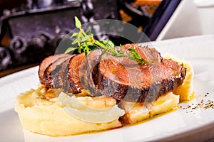 Beef with mashed potatoes on white plate