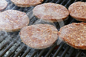 Beef meat burger patty on a hot smoky barbeque grill