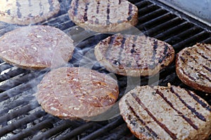 Beef meat burger patty on a hot smoky barbeque grill