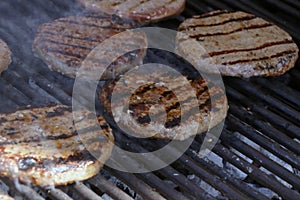 Beef meat burger patty on a hot smoky barbeque grill