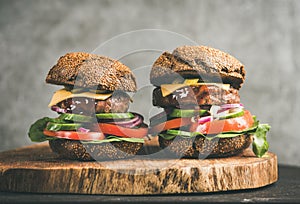 Beef meat cheeseburgers with barbeque sauce on board, close-up