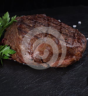 Beef medallion steak on a black background photo
