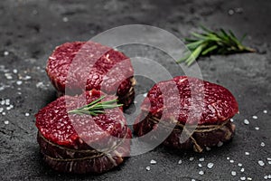Beef medallions with rosemary and spices, Raw beef meat steak Tenderloin fillet on a dark background. banner, menu, recipe place