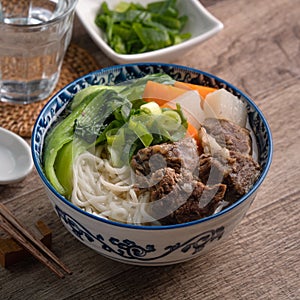 Beef noodle soup. Close up of Taiwanese famous food in a bowl on wooden table