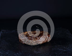 Beef patty - grilled burger on a black background