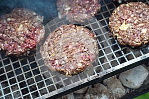 Beef or pork meat barbecue burgers for hamburger prepared grilled on bbq smoke grill in garden