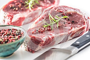 Beef Rib Eye steak with pepper and rosemary isolated on white background