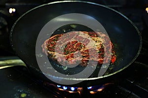 Beef rib eye steak cooking in hot non stick pan