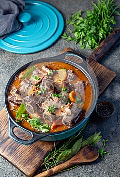 Beef ribs Bourguignonne in blue casserole. Homemade beef stew with vegetables and red wine