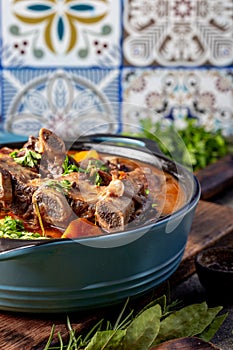 Beef ribs Bourguignonne in blue casserole. Homemade beef stew with vegetables and red wine