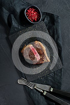 Beef rump steak roasted rare. Black background, top view.